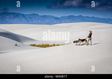 Une blonde-haired femme photographe allemand deux promenades sur les dunes de gypse Shepards au White Sands National Monument dans le Nouveau Mexique. Banque D'Images