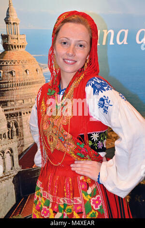 Femme en costume traditionnel de Minho qui pose pour appareil photo en face de la publicité de la ville de Viana do Castelo Minho Banque D'Images