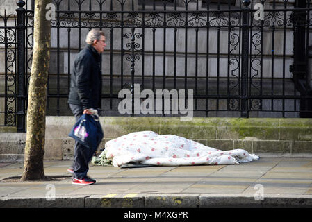 Balade par personne sans-abri dormant dans la rue à Londres. Les sans-abri. Passer en ignorant rough sleeper sur froide journée d'hiver Banque D'Images