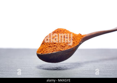 Shichimi poivre dans cuillère en bois sur la plaque en pierre noire Banque D'Images