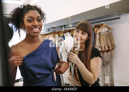 L'essai de nouveaux modèles de vêtements de créateurs dans une boutique. Femme entrepreneur dans son armure shop la conception de nouveaux vêtements. Banque D'Images