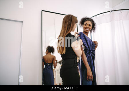 Créateur de mode de l'essai de nouveaux vêtements de créateurs sur un modèle. Femme entrepreneur dans son armure shop la conception de nouveaux vêtements. Banque D'Images