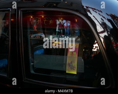 Des bannières, des lumières et des touristes restaurant reflète dans un taxi noir de Londres pendant le Nouvel An chinois 2018. Banque D'Images