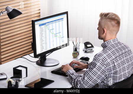 Close-up of a Businessman travaillant sur ordinateur à l'aide du diagramme de Gantt sur Office 24 Banque D'Images