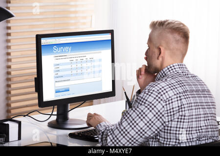 Businessman Giving Enquête en ligne sur ordinateur à l'Office de tourisme 24 Banque D'Images