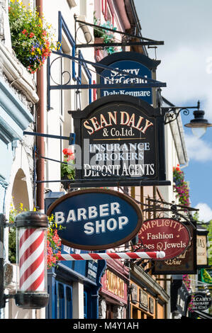 Une masse de panneaux à l'extérieur des magasins et des restaurants dans la rue animée Henry Street à Kenmare dans le comté de Kerry, en Irlande du Sud. Banque D'Images