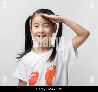 Smiling happy Asian Girls saluting Banque D'Images