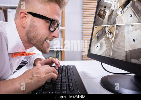 Close-up of Funny Businessman à séquences CCTV In Office Banque D'Images