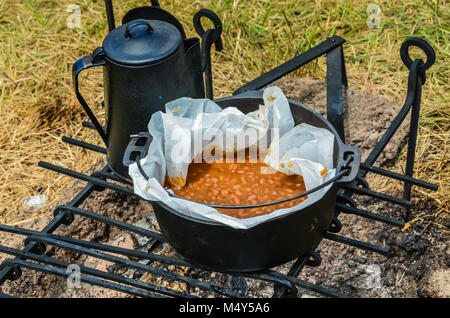 Boston traditionnels des fèves cuites au charbon chaud dans un pot en fonte noire, avec un électrique sur le côté. Banque D'Images