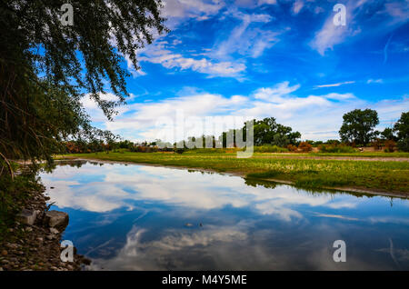 Marbré de ciel bleu et nuages blancs reflétés sur la rivière lisse le long du Canal Érié près d'Albany, NY Banque D'Images