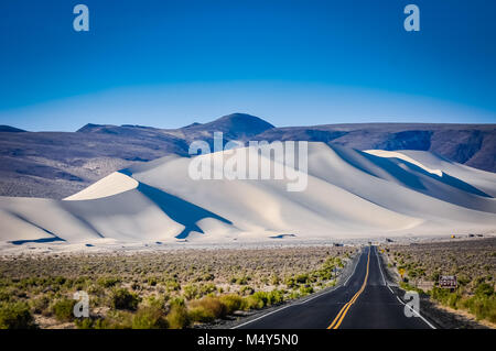 L'autoroute du Désert menant à d'immenses dunes de sable blanc en Californie. Banque D'Images