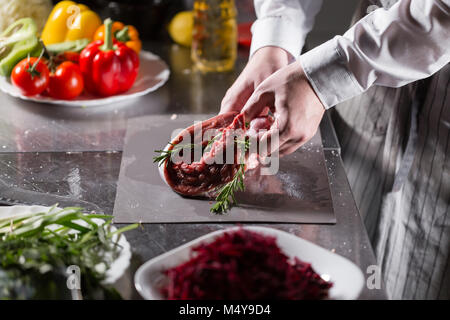 Agneaux rares prêts pour marinade avec le romarin. Avec le feu de cuisson dans une poêle. Chef professionnel dans une cuisine de restaurant. Banque D'Images