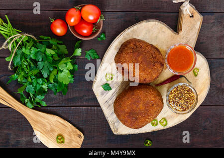 Grandes escalopes juteuses farci d'oeuf dur sur une planche à découper sur un fond de bois sombre. Scottish escalope. La vue de dessus Banque D'Images