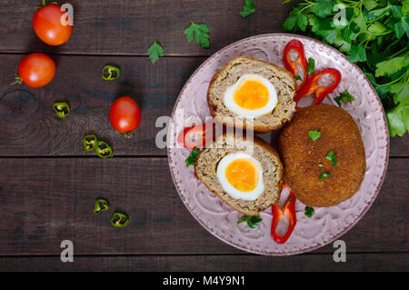 Grandes escalopes juteuses farci d'oeuf dur sur un fond de bois sombre. Scottish escalope. La vue de dessus Banque D'Images