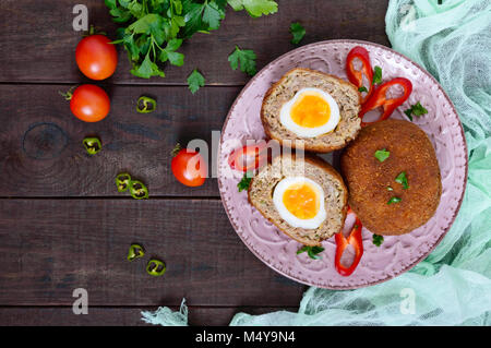 Grandes escalopes juteuses farci d'oeuf dur sur un fond de bois sombre. Scottish escalope. La vue de dessus Banque D'Images