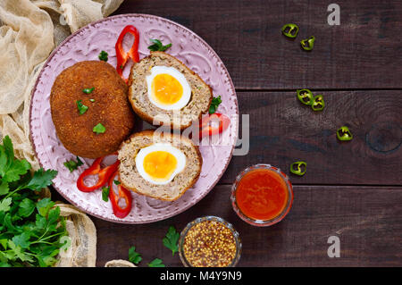 Grandes escalopes juteuses farci d'oeuf dur sur un fond de bois sombre. Scottish escalope. La vue de dessus Banque D'Images