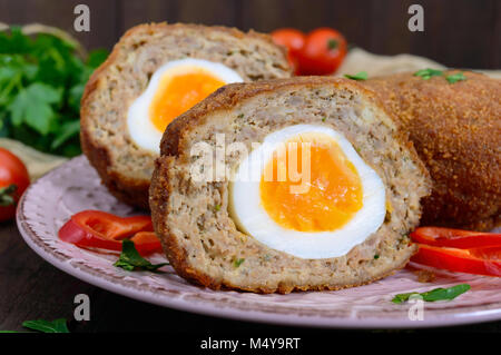 Grandes escalopes juteuses farci d'oeuf dur sur un fond de bois sombre. Scottish escalope. Banque D'Images