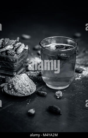 Close up de l'eau de la cardamome en poudre noire avec ses matières premières et son ensemble noir cardamome. Banque D'Images