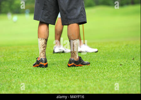 Les jambes de sale joueur de golf à jeu de pluie Banque D'Images