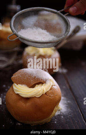 Semla crème suédois bun sur fond en bois foncé Banque D'Images