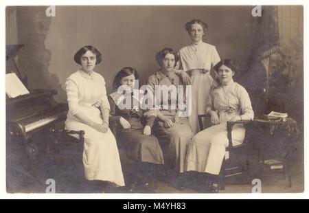 Studio portrait d'un groupe d'édouardiens de jeunes filles ou de jeunes femmes (adolescents) dans des vêtements élégants, posant à côté de la prop de piano du studio photographique de E.M. Middleton, King St., Aberdeen, Écosse, Royaume-Uni vers 1910 Banque D'Images