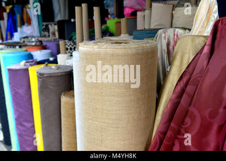 Tissu sur rool en vente au marché du textile en Thaïlande photo avec un faible éclairage en soirée en plein air. Banque D'Images