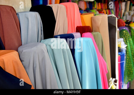 Tissu sur rool en vente au marché du textile en Thaïlande photo avec un faible éclairage en soirée en plein air. Banque D'Images