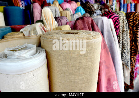 Tissu sur rool en vente au marché du textile en Thaïlande photo avec un faible éclairage en soirée en plein air. Banque D'Images