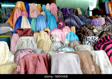 Tissu sur rool en vente au marché du textile en Thaïlande photo avec un faible éclairage en soirée en plein air. Banque D'Images