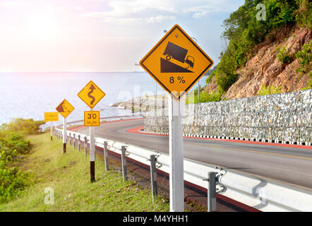 Symbole d'avertissement de trafic pour signer la protection de la route de montagne photo dans l'éclairage solaire. Banque D'Images