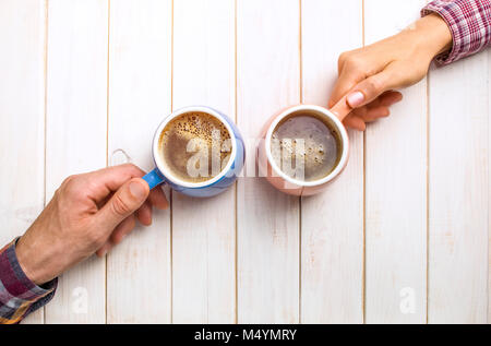 Man and Woman holding tasse de café sur un fond de bois. Deux personnes de boire du café. Couple. Les amis. Banque D'Images