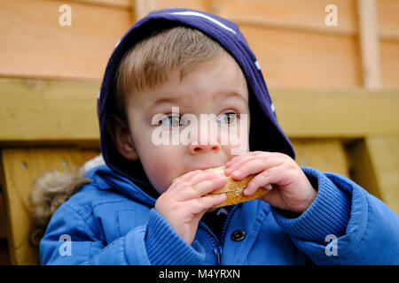 En dehors de tout-petits en train de manger un sandwich Banque D'Images