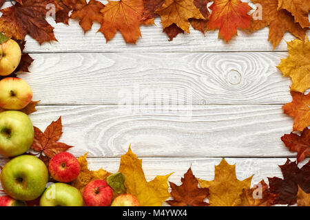 Les feuilles d'automne et les pommes sur fond de bois vieux Banque D'Images