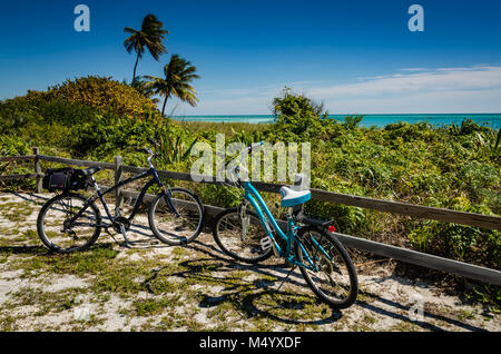 Deux bicyles, une avec un sac de selle, s'asseoir parqué par une clôture en bois sur la plage à Bahia Honda State Park dans les Florida Keys. Banque D'Images