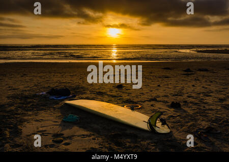 Golden glow du coucher de soleil sur la plage de lumière brille sur surf sur le sable jaune de gauche à Cardiff Beach près de San Diego, en Californie. Banque D'Images