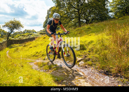 Vélo de montagne femelle sur le sentier près de Winster dans le Lake District Banque D'Images