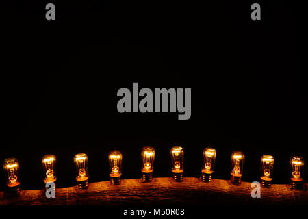 Ampoules dans arbre branche en noir bachground Banque D'Images