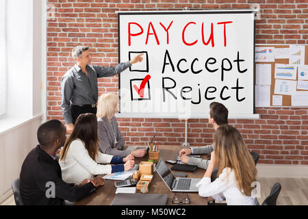 Man Presenting Paycut Concept de rejet d'un groupe de personnes Banque D'Images