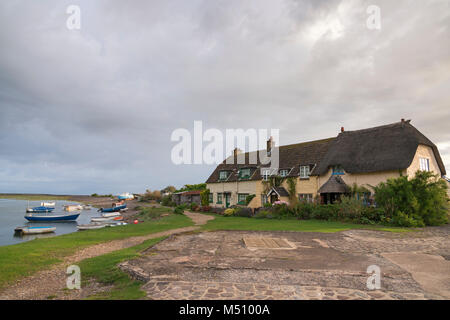 Cottages at Porlock Weir à Somerset, Angleterre sur un matin d'été avec les bateaux de pêche sur les rives de l'estuaire. Banque D'Images