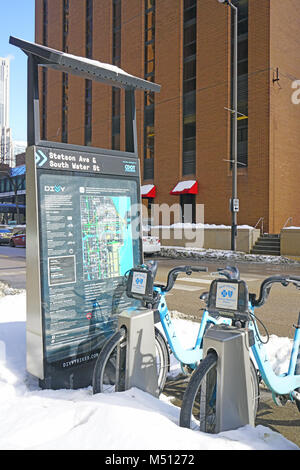 L'hiver à Chicago. La neige recouvre Partager actions vélo vélos Bixi bleue garée dans la rue dans le centre-ville de Chicago. Banque D'Images