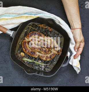 Des saucisses grillées servies par femme en mains Banque D'Images