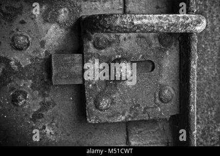 Ancienne serrure rouillée sur porte d'acier sombre, noir et blanc Banque D'Images