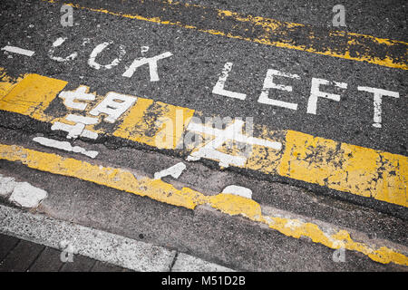 Regardez à gauche. Attention signalisation pour piétons indique la direction d'aborder la circulation dans la ville de Hong Kong Banque D'Images