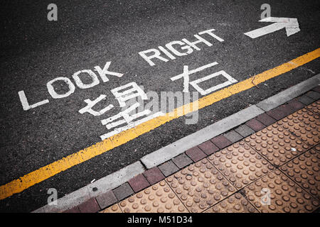 Regardez à droite. Attention signalisation pour piétons indique la direction d'aborder la circulation dans la ville de Hong Kong Banque D'Images