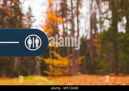 Restroom sign on blue board in autumn park Banque D'Images