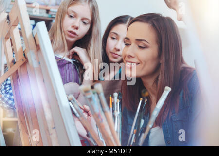 Les enfants doués à leur professeur de peinture travailler Banque D'Images