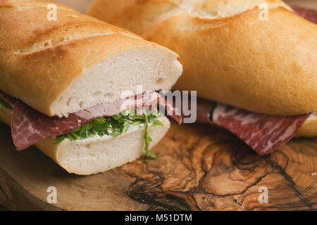 Sandwichs baguette avec coppa jambon sur bois, l'accent peu profondes Banque D'Images