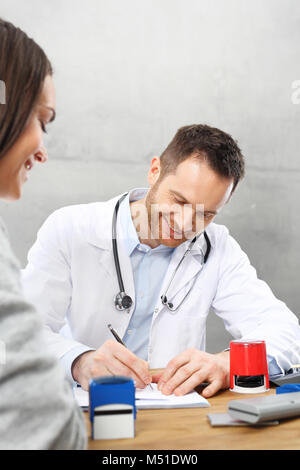 Un patient dans un cabinet de médecin. Le médecin entre recommandations et prescriptions. Banque D'Images