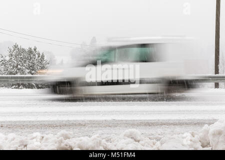 Voiture blanche, van conduite rapide sur la route en hiver paysage, avec un temps neigeux. Motion Blur Banque D'Images