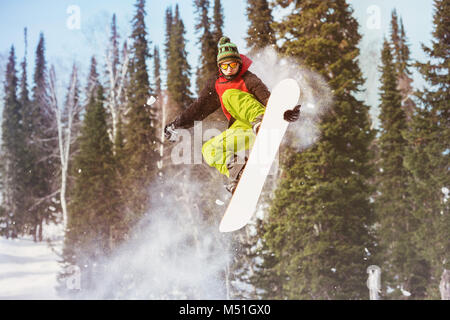 Snowboarder saute à pente hors piste Banque D'Images